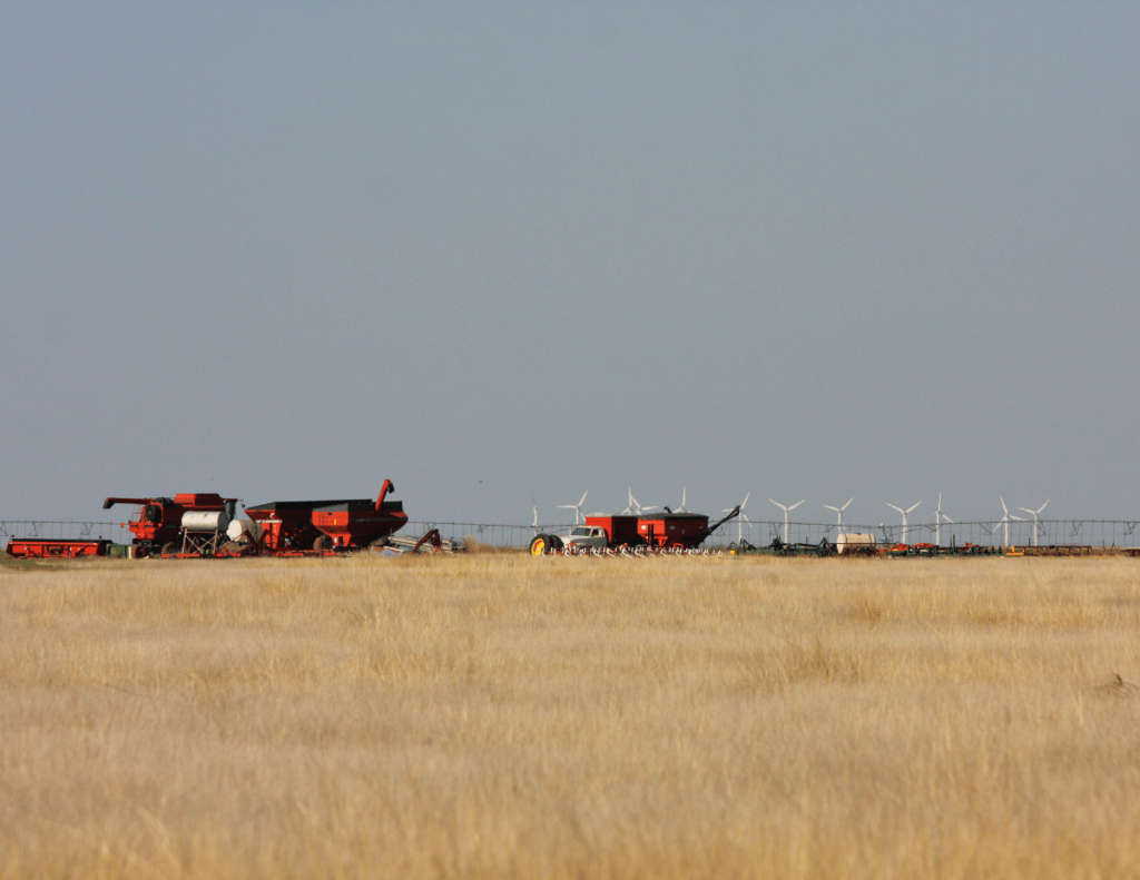 wheat field with harvesters in the back ground in Texas