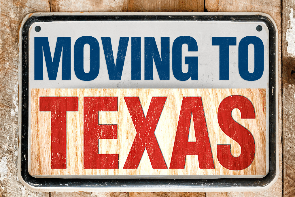 Sign on wood barn saying Moving to Texas