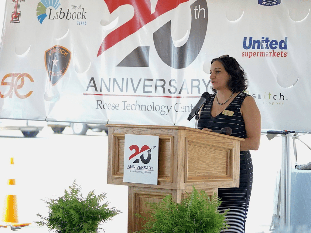 CEO Murvat Musa welcomes guest behind a podium at 20 year celebration for reese technology Center
